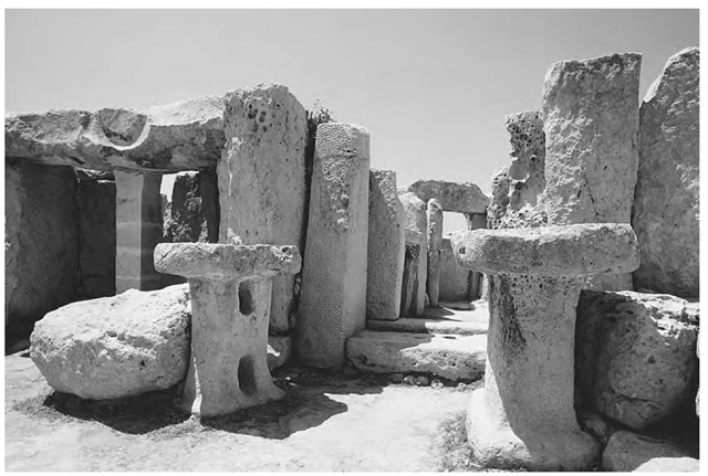 Monolithic altars stand at the ruins of Hagar Qim, a Neolithic temple on Malta. The pits and pockmarks in the limestones are caused by long-term erosion. 