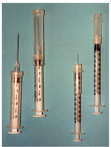 One type of safety syringe. After drawing up the solution to be injected or drawing blood, the sheath is pulled out and clicked into place, but not locked. This covers the needle while it is transported. The sheath is retracted straight back to administer the injection, and is again pulled out and twisted, to lock it in place, when the injection is completed. This avoids the dangerous practice of recapping needles. Shown are a 3-mL syringe with a 22-G, i /-inch needle (for IM injections) and a 1-mL insulin syringe with a 29-G, /2-inch needle. Each is shown with the sheath retracted and with the sheath in place.